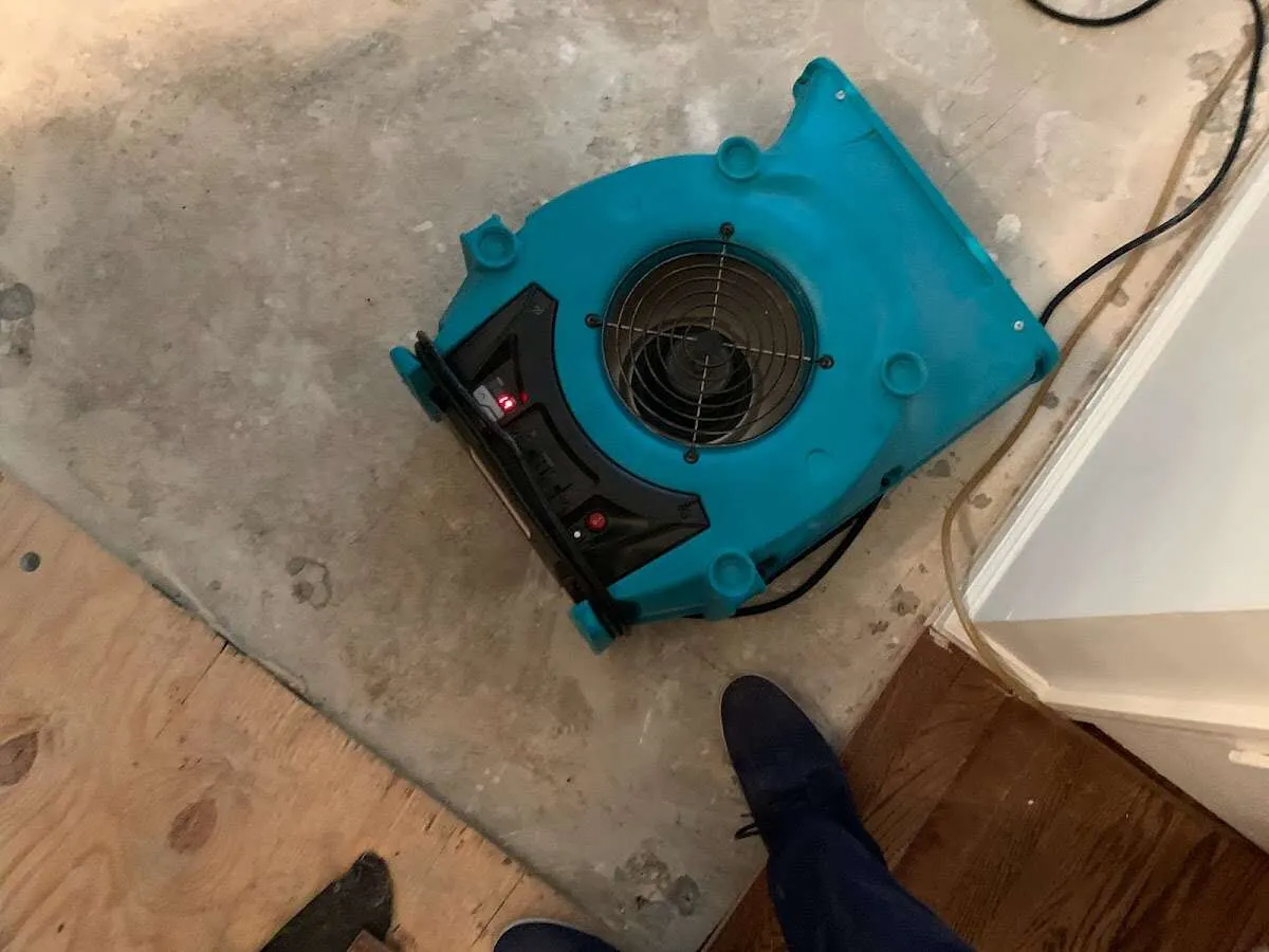 Air mover drying subfloor during Commercial Water Damage Restoration in Dickinson